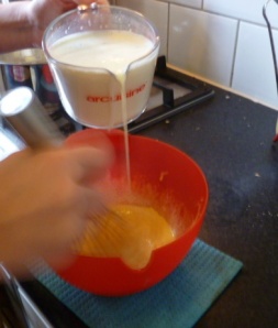 Adding milk to eggs to make custard, slowly at first